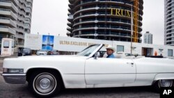 Un hombre pasea en su descapotable frente a la Torre Trump que se está construyendo en Punta del Este, Urugauy.