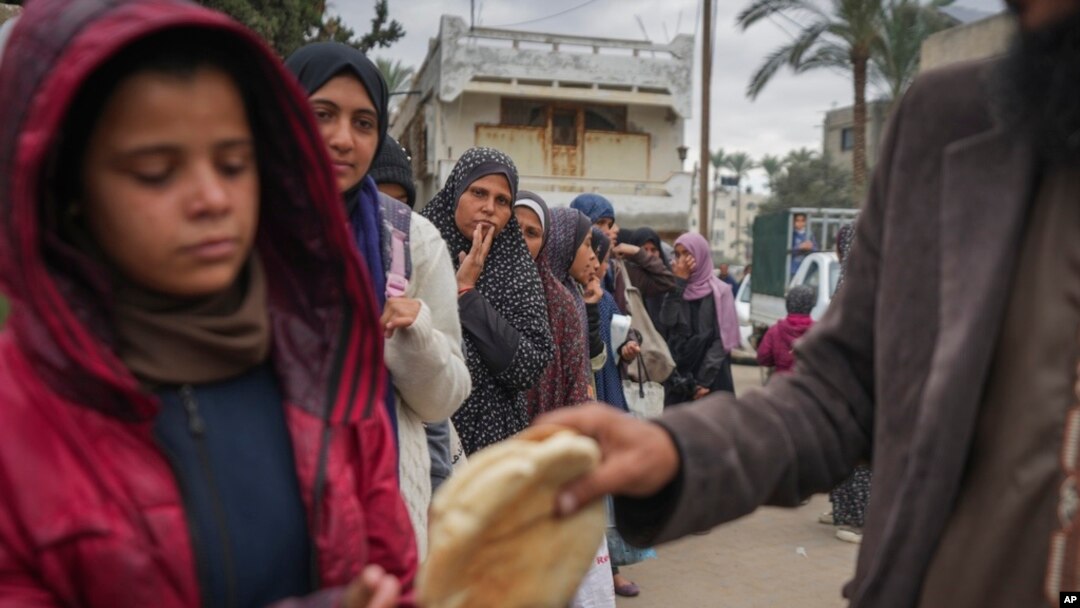 Mujeres y niños palestinos hacen cola para comprar pan en Deir al-Balah, Franja de Gaza, el jueves 28 de noviembre de 2024. (Foto AP/Abdel Kareem Hana)