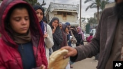 Mujeres y niños palestinos hacen cola para comprar pan en Deir al-Balah, Franja de Gaza, el jueves 28 de noviembre de 2024. (Foto AP/Abdel Kareem Hana)