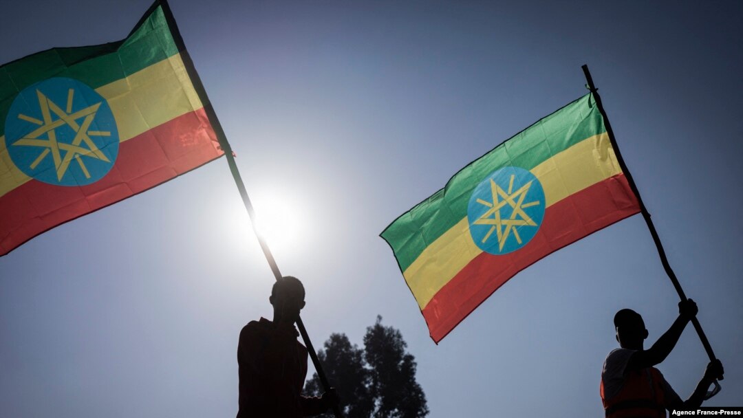 New military recruits who are joining the Ethiopian National Defense Force hold Ethiopian national flags during the send-off ceremony in Addis Ababa, Nov. 24, 2021.
