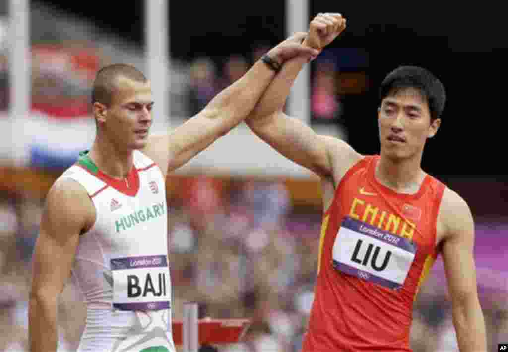 China's Liu Xiang, right, and Hungary's Balazs Baji, left, react after Liu's fall in a men's 110-meter hurdles heat during the athletics in the Olympic Stadium at the 2012 Summer Olympics, London, Tuesday, Aug. 7, 2012. (AP Photo/Anja Niedringhaus)