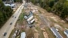 Homes and vehicles that were damaged in a flash flood from Hurricane Helene lie on the side of a road near the Swannanoa River, in Swannanoa, North Carolina, Oct. 1, 2024. 