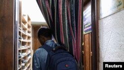 FILE - Mamadou Safaiou Barry walks inside the center where he studies Islam and the Koran in Cairo, Egypt, September 23, 2023. After embarking on a four-month cycling journey across seven countries, Barry arrived in Cairo, to study Islam in Al-Azhar University in Egypt. 