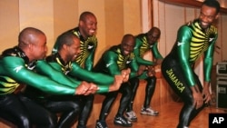 FILE - Dudley Stokes, captain of the Jamaican bobsled team for the Nagano Winter Olympics (R), smiles back at his team members as they demonstrate the bobsled pushing form during a sending-off reception for the team at a Tokyo hotel, Feb. 4, 1998.