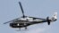 FILE - A police helicopter flies as police officers boost security around Cairo's Tahrir Square on Nov. 18, 2013. 