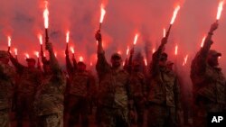 Soldiers of Ukraine's Azov battalion light flares at a rally demanding the release of Ukrainian prisoners of war who are held in captivity in Russia, at Independence Square in Kyiv, Ukraine, July 28, 2024. 