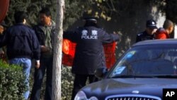 A policeman looks at a banner that a supporter of dissident Chinese artist Ai Weiwei tried to display outside the artist's house in Beijing, November 14, 2011.