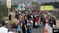 Palestinians walk down a road as they flee Gaza City and other parts of northern Gaza towards the southern areas on November 8, 2023 amid ongoing battles between Israel and the Palestinian Hamas movement. (Photo by MOHAMMED ABED / AFP)