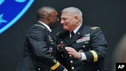 Outgoing Africa Command commander US General William Ward, left, shakes hands with his successor US commander General Carter Ham during the AFRICOM change of command ceremony in Sindelfingen near Stuttgart, March 9, 2011