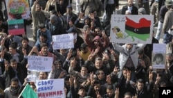 Libyan protesters hold signs and shout slogans against Libyan Leader Moammar Gadhafi during a demonstration, in Tobruk, February 23, 2011