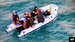 This image provided by the French navy shows migrants aboard a rubber boat after being intercepted by French authorities, off the port of Calais, northern France, Dec. 25, 2018.