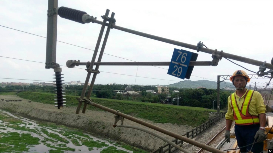 Seorang petugas jawatan kereta api berdiri di dekat tiang yang ambruk akibat gempa di dekat Hualien, kawasan timur Taiwan, 18 April 2019.