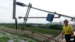 Seorang petugas jawatan kereta api berdiri di dekat tiang yang ambruk akibat gempa di dekat Hualien, kawasan timur Taiwan, 18 April 2019.