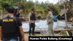 Polisi memeriksa bangunan yang dibakar dalam serangan kelompok teroris Mujahidin Indonesia Timur (MIT) pimpinan Ali Kalora di Dusun Lewonu, Desa Lemban Tongoa, Kecamatan Palolo, Kabupaten Sigi, Sulawesi Tengah, Sabtu (28/11/2020). (Foto: Courtesy/Humas Po