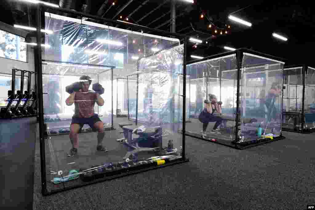 People exercise in their workout pods while observing social distancing at Inspire South Bay Fitness, June 15, 2020, in Redondo Beach, as the gym reopens under California&#39;s coronavirus Phase 3 reopening guidelines.