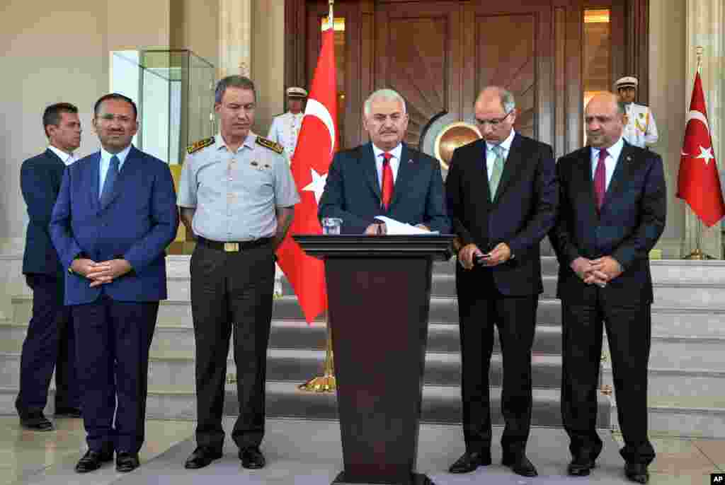Turkey's Prime Minister Binali Yildirim, center, Chief of Staff Gen. Hulusi Akar, center left, Justice Minister Bekir Bozdag, left, Interior Minister Efkan Ala, second right, and Defense Minister Fikri Isik attend a press conference in Ankara, Turkey, Sat