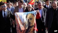 FILE - A man holds a cloth with a depiction of the late Spanish dictator Francisco Franco, during the reinterment of his remains, outside Mingorrubio's cemetery, on the outskirts of Madrid, Spain, Oct. 24, 2019. 
