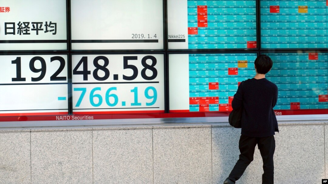 A man looks at an electronic stock board showing Japan's Nikkei 225 index at a securities firm in Tokyo, Jan. 4, 2019. Japanese markets have tumbled as they reopened after the New Year holidays, while other Asian indexes are mixed after a technology-led sell-off on Wall Street.