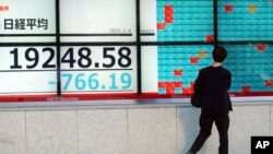 A man looks at an electronic stock board showing Japan's Nikkei 225 index at a securities firm in Tokyo Friday, Jan. 4, 2019. 