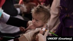 ফাইল ছবিতে দেখা যাচ্ছে, আফগানিস্তানের কান্দাহার প্রদেশের নাসাজি গ্রামে ভ্রাম্যমাণ স্বাস্থ্য ও পুষ্টি দলের একজন নার্স একটি শিশুর স্বাস্থ্য পরীক্ষা করছেন। 