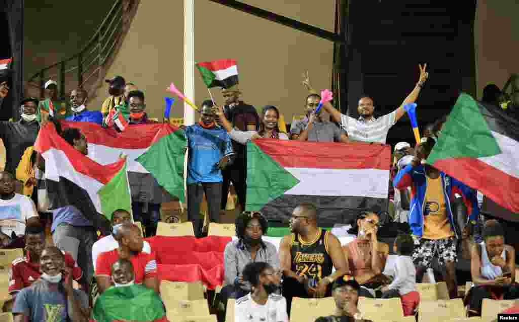 Sudan fans hold up with flags inside the stadium before the football match between Egypt and Sudan, in Cameroon, Jan. 19, 2022.