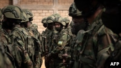 FILE - Rwandan soldiers policemen prepare to board a plane for a military mission in Mozambique, at Kanombe airport, Kigali, Rwanda, July 10, 2021.