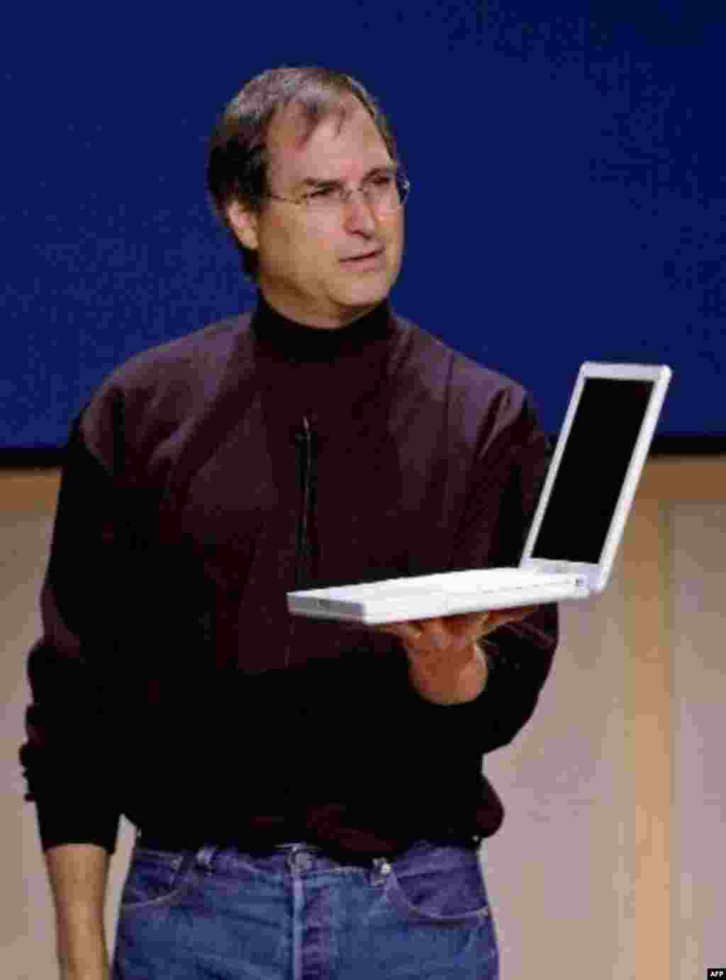 Apple Computers Inc. chief executive officer Steve Jobs holds up the new laptop iBook at a press conference at Apple headquarters in Cupertino, Calif., Tuesday, May 1, 2001. The new ibook will be available in mid-May with a retail price of $1,299 and has 