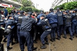 FILE - Algerian police officers block protesters from advancing during a demonstration in the capital Algiers, Feb. 22, 2021.