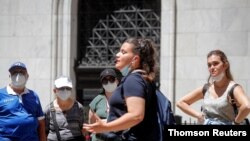 지난달 미국 뉴욕시 월스트리트 증권거래소 앞에 신종 코로나바이러스 감염 예방 마스크를 쓴 관광객들이 서 있다. 