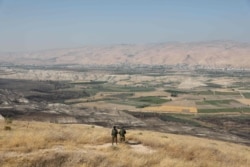 FILE - Israeli soldiers stand guard in an old army outpost overlooking the Jordan Valley between the Israeli city of Beit Shean and the West Bank city of Jericho, June 23, 2019.