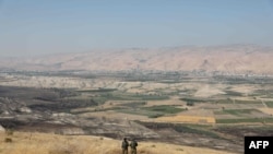 In this file photo taken on June 23, 2019 Israeli soldiers stand guard in an old army outpost overlooking the Jordan Valley between the Israeli city of Beit Shean and the West Bank city of Jericho.