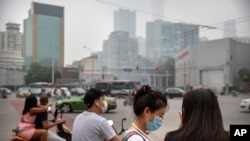 11일 중국 베이징 시민들이 마스크를 한 채 신호등을 기다리고 있다. 