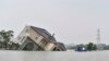 A woman and a young girl sit in their flooded house in Sunamganj, Bangladesh.