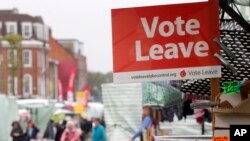 FILE - A Vote Leave sign is fixed on a market stall at Havering's Romford street market in London, June 1, 2016, ahead of Britain's Brexit referendum. 