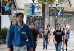 FILE - Students students walk outside the Pauley Pavilion basketball arena at the University of California-Los Angeles, Nov. 15, 2017.