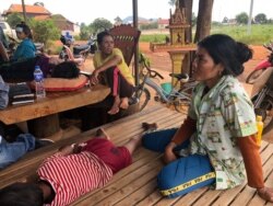 Some villagers look after children who have been diagnosed with dengue fever at a private health clinic in the village, June 2019. (Sun Narin/VOA Khmer)