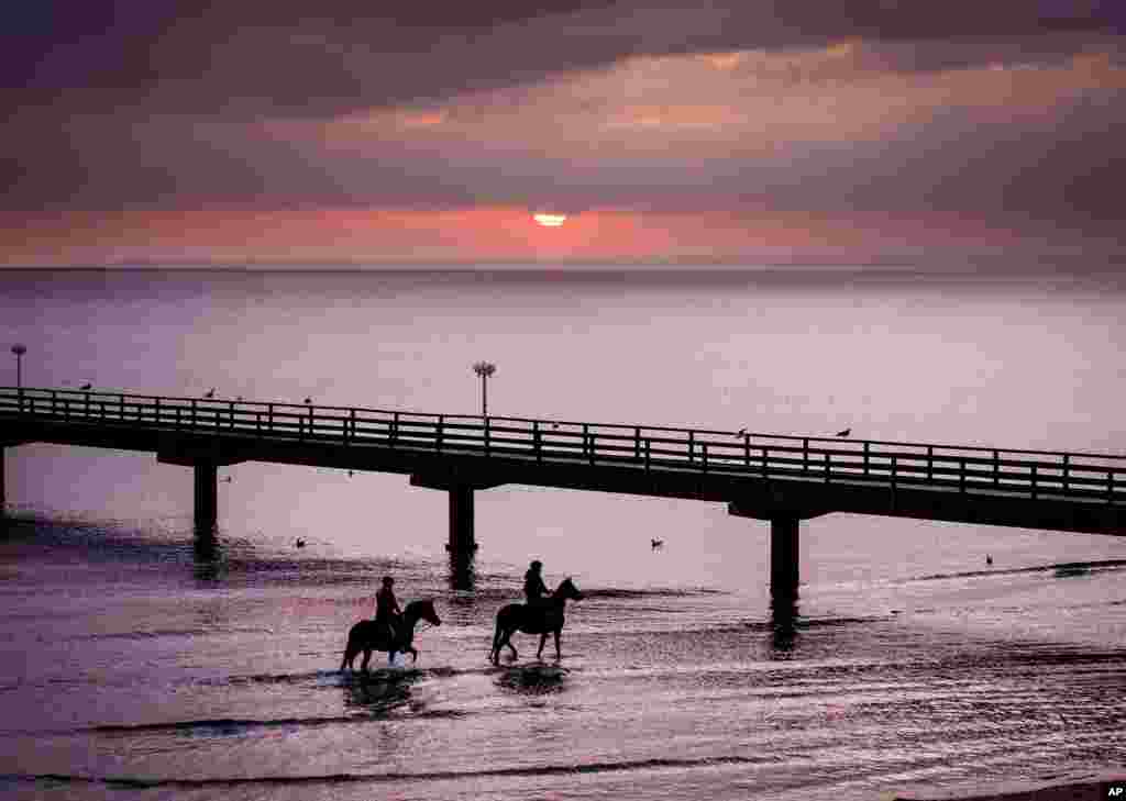 Two young women ride their horses alaTwo young women ride their horses along the shore of the Baltic Sea in Scharbeutz, Germany.ong the shore of the Baltic Sea in Scharbeutz, northern Germany.