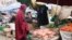 A woman buys vegetables from a local vendor in the Eastleigh neighborhood of Nairobi. The neighborhood is under lockdown after a spike in COVID-19 cases. (Mohammed Yusuf/VOA)