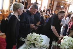 Relatives mourn over the coffins of Livia Florentian Bunea, 36, from Romania and her daughter Elena Natalia, 8, in Arediou, Cyprus, June 13, 2019. The mother and daughter are believed to have been victims of a serial killer.