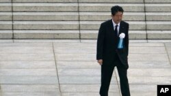 FILE - In this Aug. 6, 2020 photo, Japanese Prime Minister Shinzo Abe walks off after delivering a speech during a ceremony to mark the 75th anniversary of the bombing at the Hiroshima Peace Memorial Park, in Hiroshima, western Japan. 