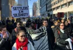 FILE - Protesters walk through the streets of Ottawa, Ontario, on Feb. 24, 2020, in support of a small group fighting construction of a natural gas pipeline on indigenous lands in British Columbia.