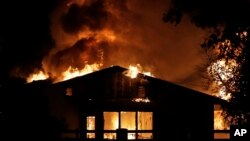 A home goes up in flames in a wildfire zone, Oct. 24, 2019, in Santa Clarita, Calif.