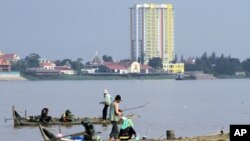 People fish on wooden boats on the Mekong River in Phnom Penh, Aug. 19, 2010. (file photo)