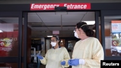 FILE - Nurses talk outside the emergency room at Beaumont Hospital as they manage an influx of COVID-19 cases in Grosse Pointe, Michigan, April 16, 2021.