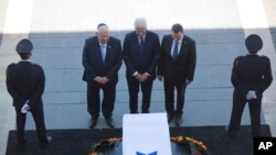 L'ancien président américain Bill Clinton, au centre, accompagné du président Reuven Rivlin d'Israël, à gauche, et Yuli Edelstein, le Président de la Knesset, s’inclinent devant le cercueil de l'ancien président israélien Shimon Peres à la place de la Knesset à Jérusalem, 29 septembre 2016. 