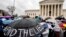 An abortion rights supporter holds an umbrella that reads "#EndTheLies" during a rally outside the Supreme Court in Washington, March 20, 2018, as the court hears arguments in a free speech fight over California's attempt to regulate anti-abortion crisis centers. On Tuesday, the court ruled against the protesters and in the favor of the centers not to have to disclose the availability of free abortion options to women wishing to terminate their pregnancies.
