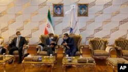 El director de la Agencia Internacional de Energía Atómica, Rafael Grossi, escucha al vocero de la agencia nucelar iraní tras su llegada a Teherán para intentar inspeccionar dos sitios.
