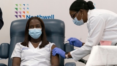 Sandra Lindsay, seorang perawat di Long Island Jewish Medical Center, menerima suntikan vaksin Covid-19 produksi Pfizer-BioNTech di Queens, New York hari Senin (14/12). 