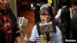 FILE - A fan livestreams her participation during China's premiere of the film "Warcraft" at a theater in Shanghai, China, June 7, 2016. 