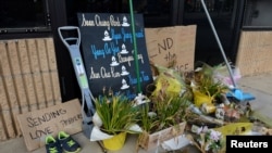 Dried flowers, signs and several brooms, squeegees and shovels block the entry of the Aromatherapy Spa in Atlanta, four weeks after the deadly shootings in Atlanta and Acworth, Georgia, April 13, 2021.